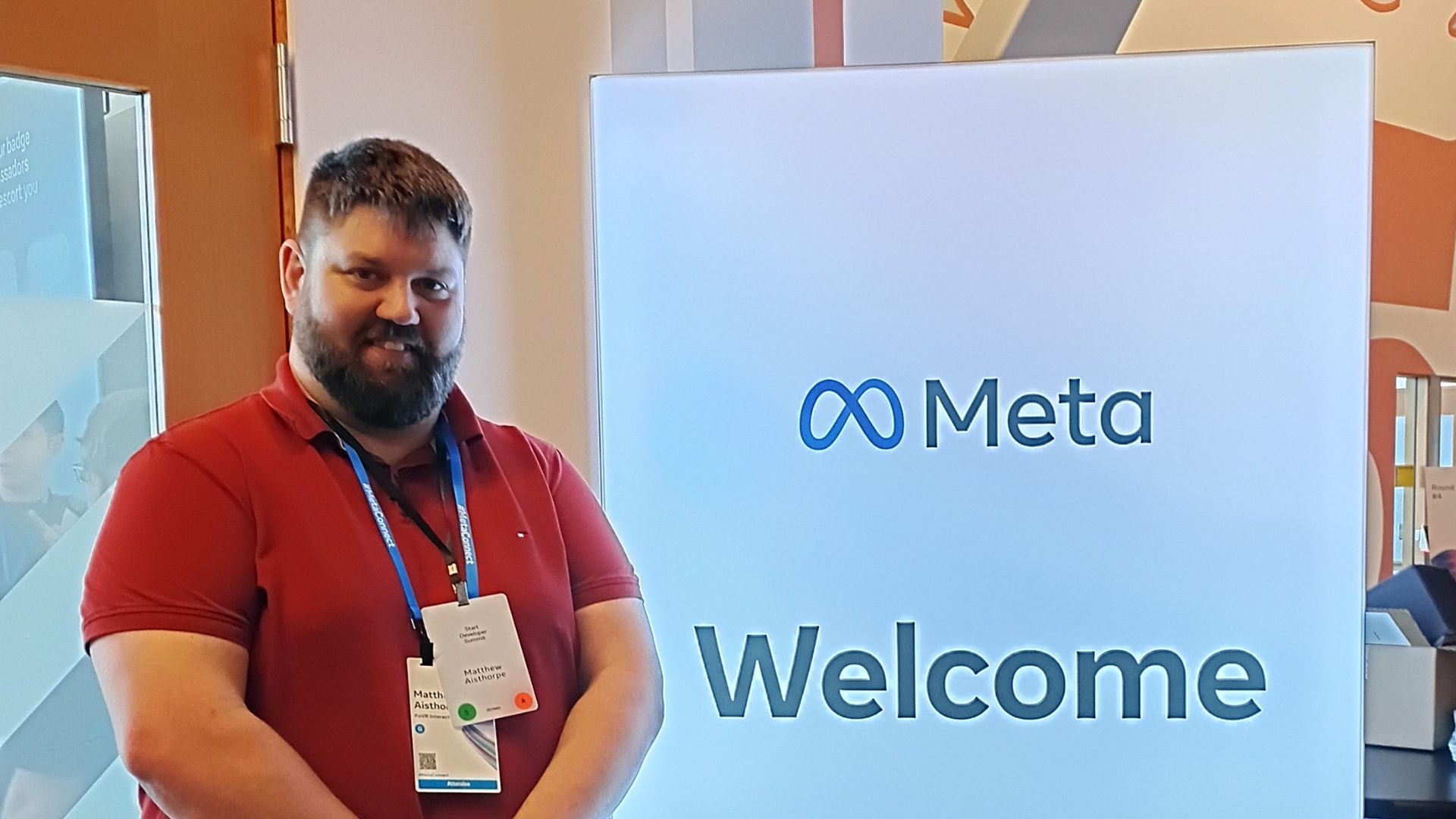 Matthew Aisthorpe standing next to the Meta Welcome Sign